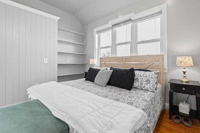 bedroom featuring lofted ceiling and wood finished floors