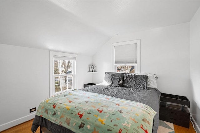 bedroom with baseboards, wood finished floors, and vaulted ceiling