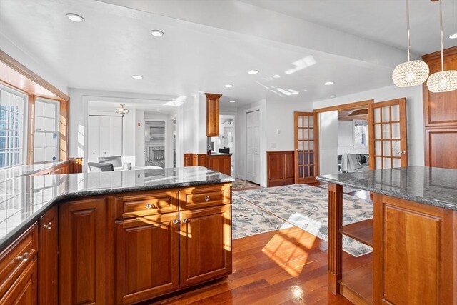 kitchen featuring brown cabinetry, dark wood finished floors, recessed lighting, french doors, and wainscoting