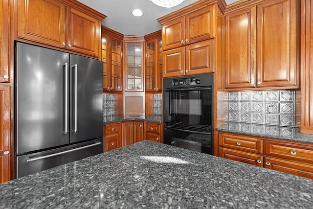 kitchen featuring brown cabinets, high end fridge, and dobule oven black