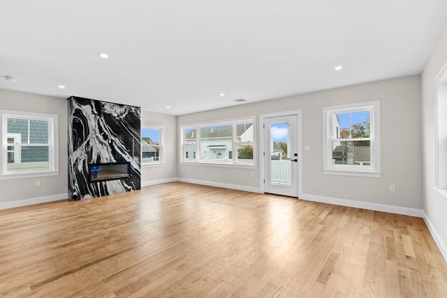 unfurnished living room with light hardwood / wood-style flooring and plenty of natural light