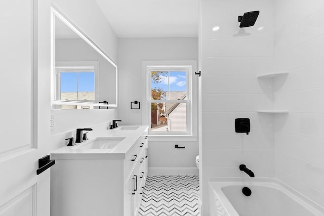 full bathroom featuring vanity, tiled shower / bath combo, and toilet