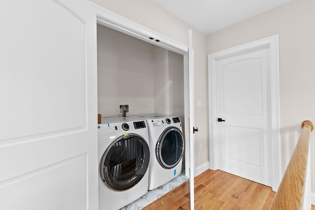 washroom with hardwood / wood-style flooring and washer and clothes dryer