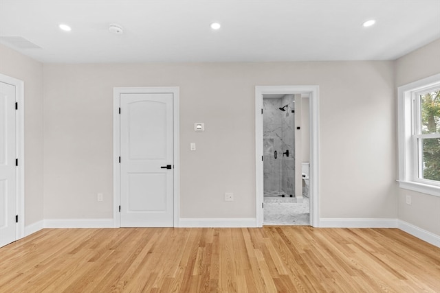 unfurnished bedroom with light wood-type flooring and ensuite bath