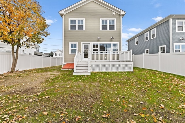 back of house featuring a deck and a lawn