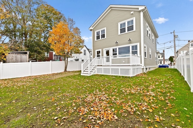 back of house featuring a yard and a wooden deck