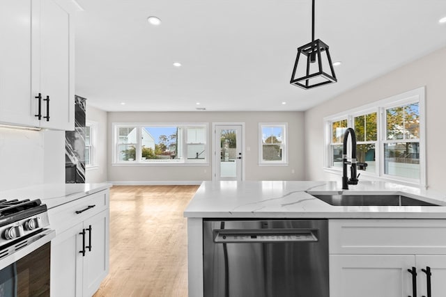 kitchen featuring a wealth of natural light, white cabinets, and stainless steel appliances