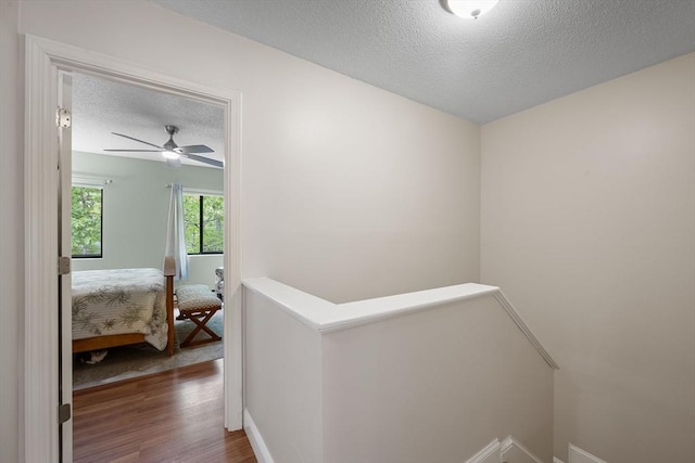 15 Roundhouse Rd Unit 15, Bourne, MA 02532 - hallway with an upstairs landing, a textured ceiling, wood finished floors, and baseboards