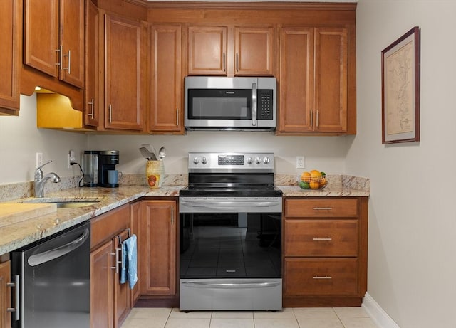 15 Roundhouse Rd Unit 15, Bourne, MA 02532 - kitchen featuring appliances with stainless steel finishes, a sink, brown cabinets, and light tile patterned floors