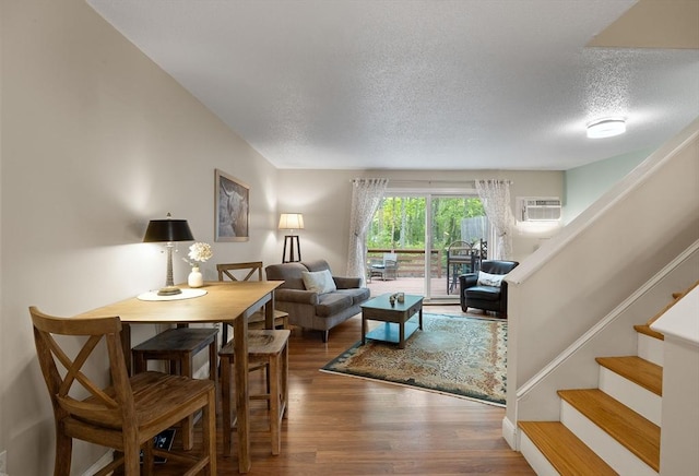15 Roundhouse Rd Unit 15, Bourne, MA 02532 - living room with wood finished floors, a textured ceiling, stairs, and an AC wall unit
