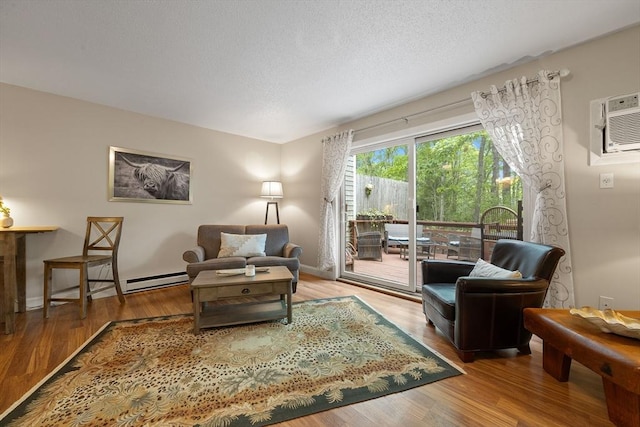 15 Roundhouse Rd Unit 15, Bourne, MA 02532 - living area with wood finished floors, a textured ceiling, an AC wall unit, a baseboard heating unit, and baseboards