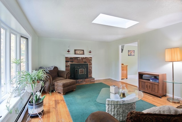 living room featuring hardwood / wood-style flooring, a skylight, and a wood stove