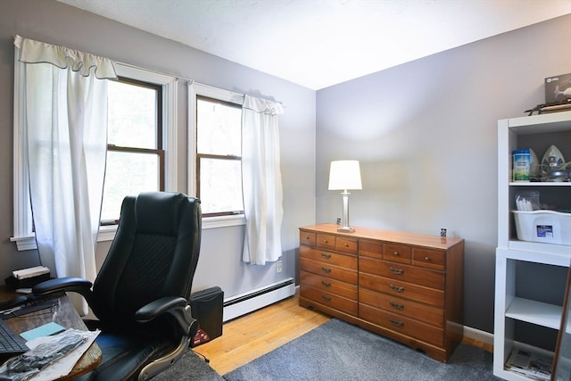 office area with baseboard heating and light hardwood / wood-style flooring