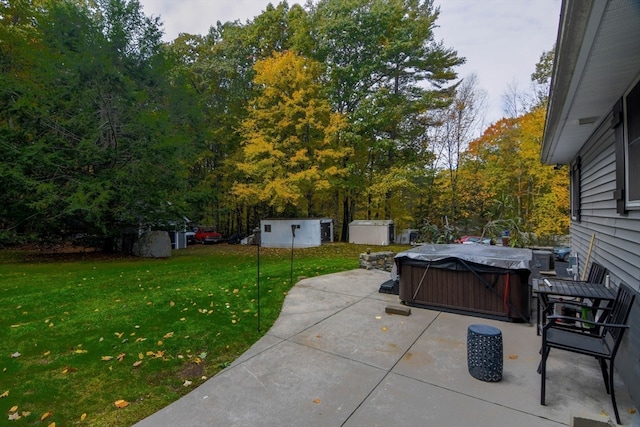 view of patio / terrace with a hot tub and a storage shed