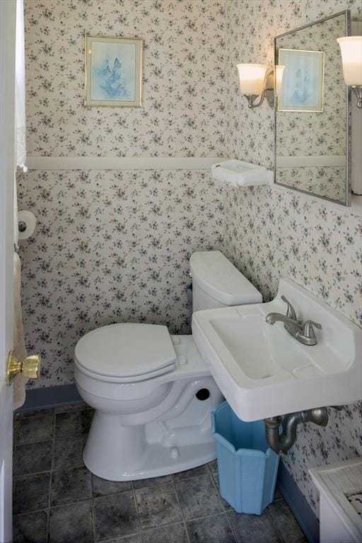 bathroom with tile patterned flooring, a sink, toilet, and wallpapered walls