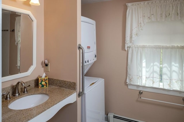 laundry room featuring laundry area, a sink, a baseboard heating unit, and stacked washer / dryer