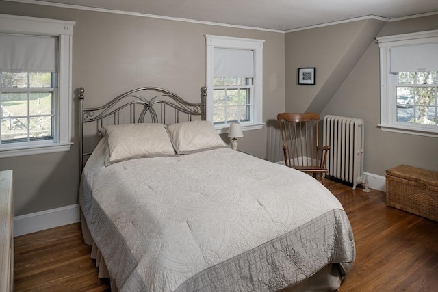 bedroom with baseboards, radiator heating unit, and wood finished floors