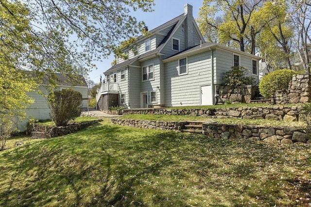rear view of property featuring a yard and a chimney