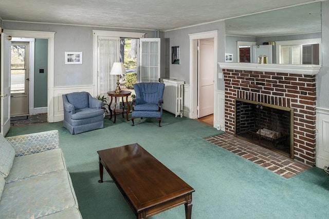 carpeted living room featuring ornamental molding, radiator, and a fireplace