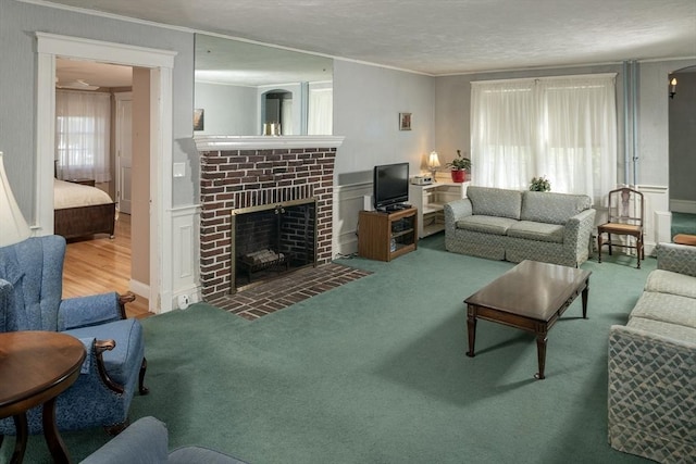 living area featuring ornamental molding, a textured ceiling, and a brick fireplace