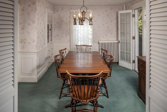 dining area with wallpapered walls, an inviting chandelier, wainscoting, and dark carpet