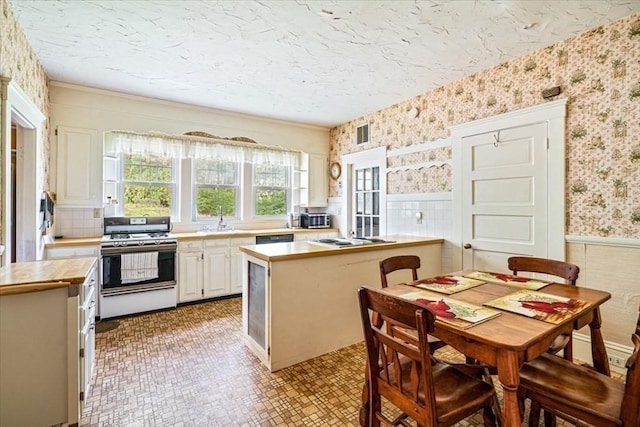 48 Neal Gate St, Scituate, MA 02066 - kitchen with wood counters, a sink, visible vents, wallpapered walls, and white gas stove