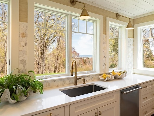 kitchen featuring a sink, light countertops, and white cabinetry