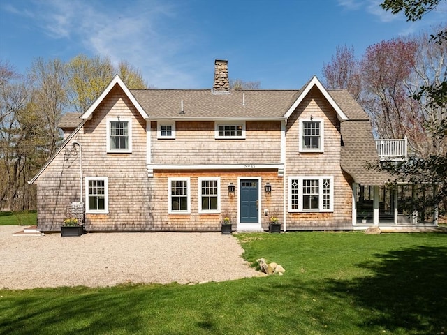 back of property featuring a patio, a shingled roof, a yard, and a chimney