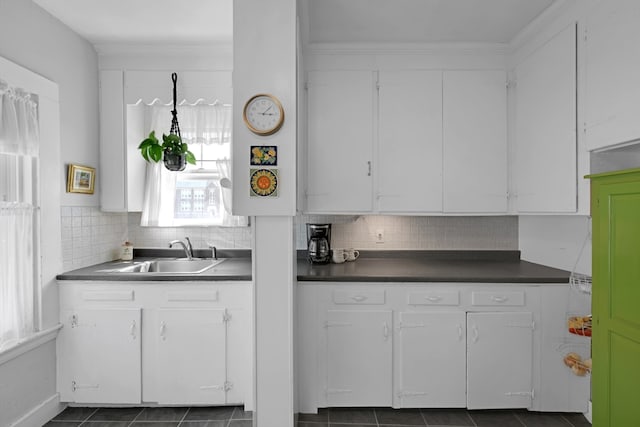 246 Railroad Ave, Norwood, MA 02062 - kitchen with healthy amount of natural light, dark countertops, white cabinetry, decorative backsplash, and ornamental molding