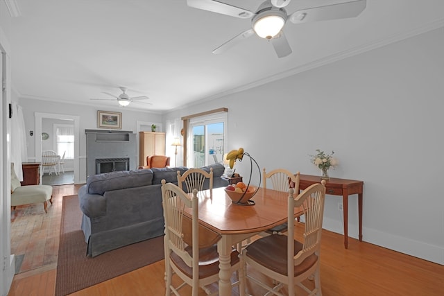 246 Railroad Ave, Norwood, MA 02062 - dining space with ceiling fan, light wood-style floors, ornamental molding, and a brick fireplace