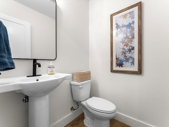half bathroom with toilet and baseboards