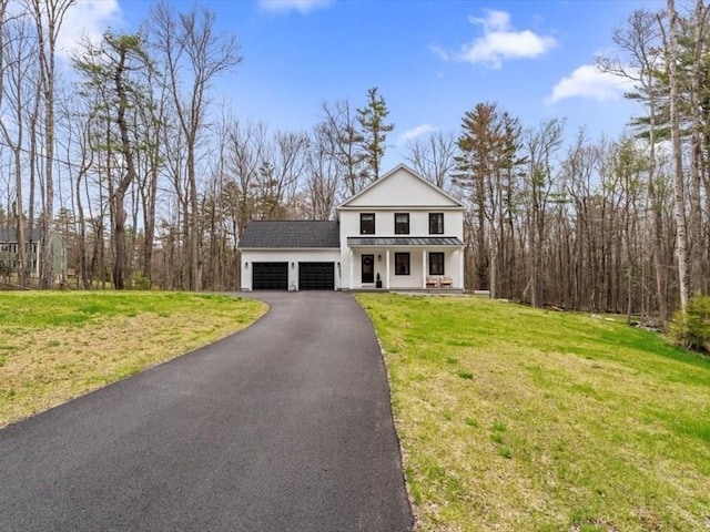 greek revival inspired property with a front lawn, aphalt driveway, an attached garage, a standing seam roof, and a porch