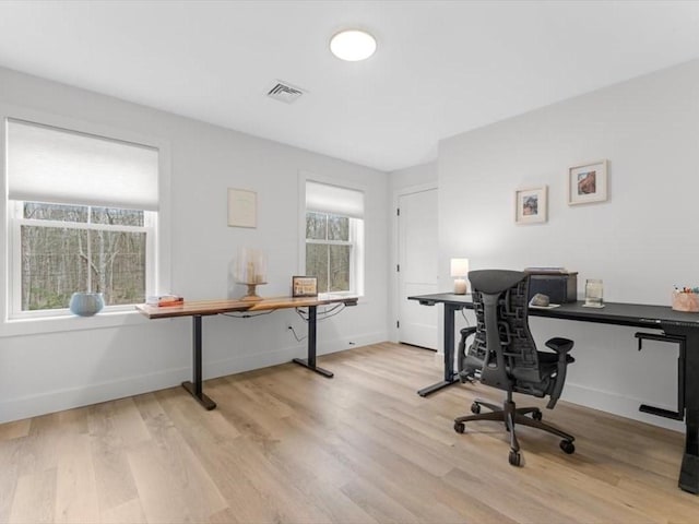 home office with visible vents, light wood-style flooring, and baseboards