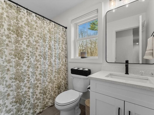 bathroom featuring toilet, tile patterned floors, and vanity
