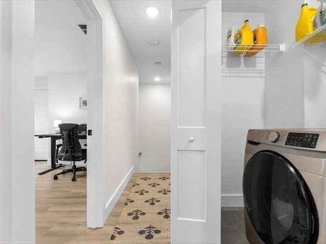 laundry room with laundry area, visible vents, wood finished floors, baseboards, and washer / clothes dryer