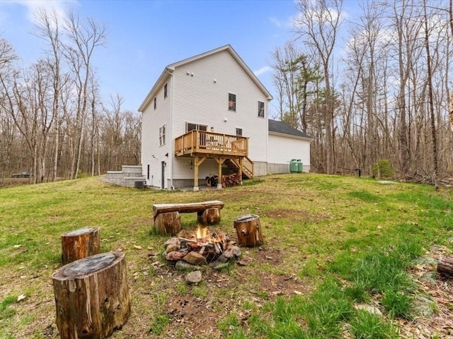 rear view of house with a lawn, an outdoor fire pit, a deck, and stairway