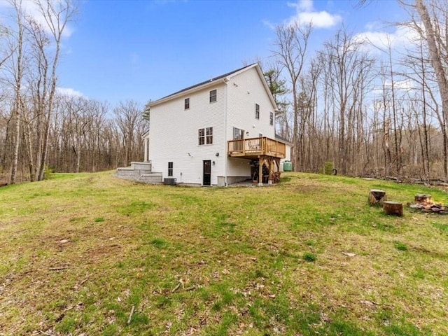 rear view of house with a yard, a deck, and central AC