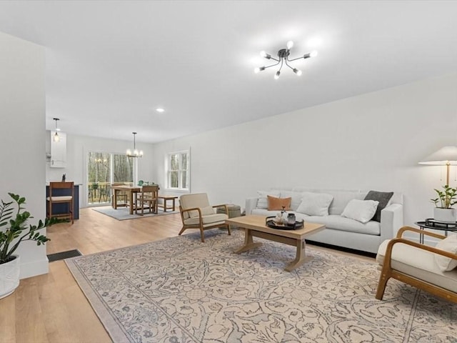 living area featuring an inviting chandelier, recessed lighting, light wood-style flooring, and baseboards