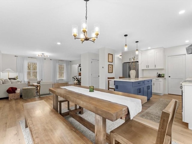 dining space with light wood-style floors, recessed lighting, and a chandelier