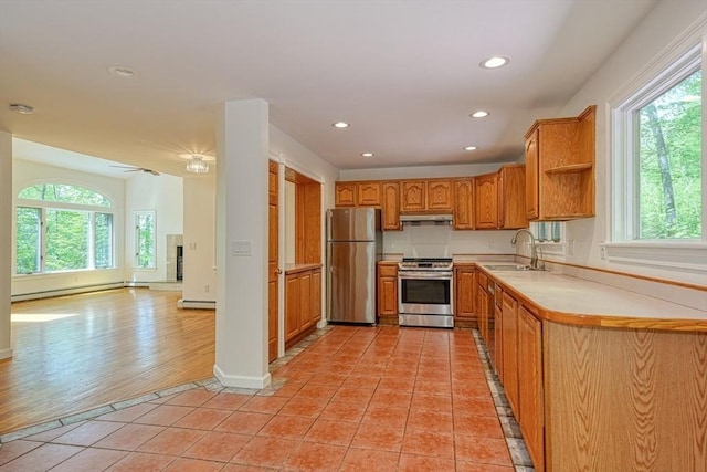 kitchen featuring appliances with stainless steel finishes, a sink, healthy amount of natural light, under cabinet range hood, and recessed lighting