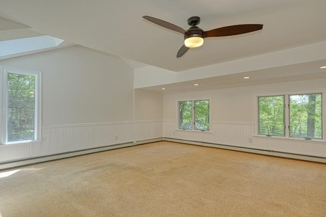 empty room featuring wainscoting, healthy amount of natural light, ceiling fan, carpet flooring, and recessed lighting