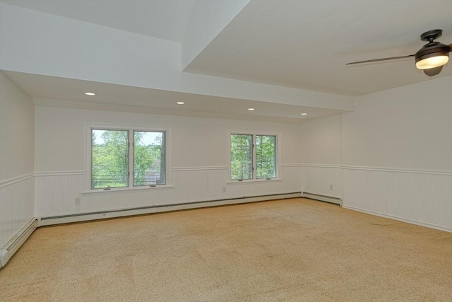carpeted spare room featuring wainscoting, a baseboard radiator, ceiling fan, and recessed lighting