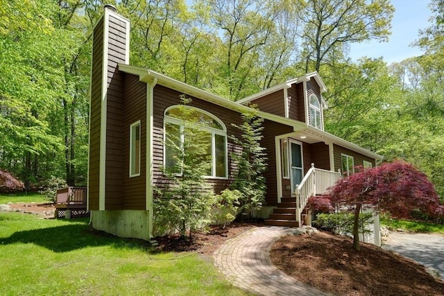 view of side of home with a chimney and a yard