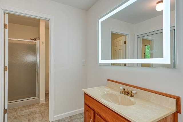 bathroom featuring a stall shower, baseboards, and vanity
