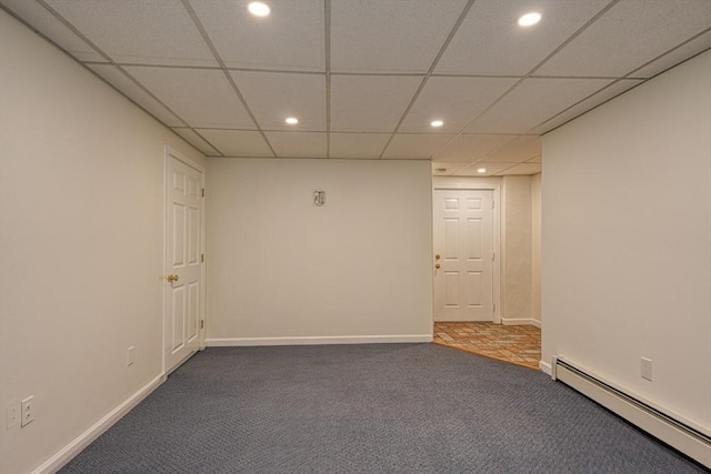finished basement featuring a baseboard radiator, carpet, recessed lighting, baseboards, and a paneled ceiling