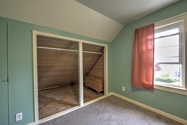 unfurnished bedroom with vaulted ceiling, baseboards, and carpet floors