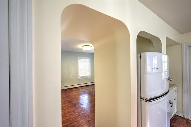 corridor with baseboard heating and dark wood-type flooring