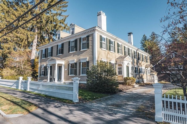 view of front of house featuring a fenced front yard and a chimney