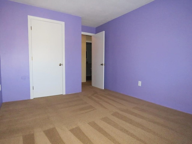 unfurnished bedroom with light colored carpet