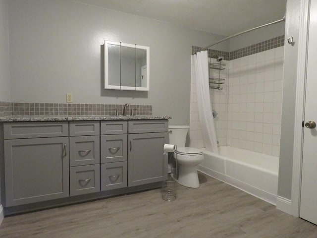 full bathroom with toilet, vanity, shower / bathtub combination with curtain, and hardwood / wood-style floors